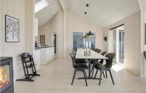 una sala da pranzo con tavolo, sedie e camino di Lovely Home In Idestrup With Wifi a Bøtø By