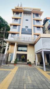 a large building with a walkway in front of it at Hotel Plaza Heights by RAK Rooms, Mangaluru in Mangalore