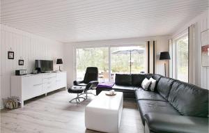 Vester SømarkenにあるCozy Home In Nex With Wifiのリビングルーム(黒い革張りのソファ、椅子付)