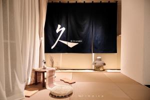 名古屋久HISASHI 今池 Nagoya的一间设有横幅、椅子和桌子的房间