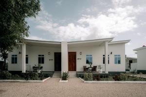 Casa blanca con un gran patio delantero en BT Private Villas with Swimming Pool, en Mkunguni
