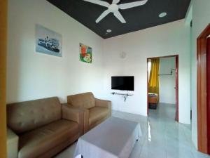 a living room with a couch and a ceiling fan at Aja Retreat Chalet in Jitra