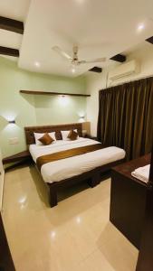 Hotel Plaza Heights في منغالور: غرفة نوم بسرير وسقف