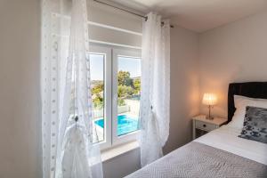 a bedroom with a window with a view of a pool at Holiday Home Sevid in Sevid
