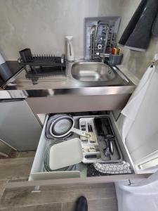 an open kitchen drawer with a sink and utensils at Studio 1 à La Trinité proche de Nice, Monaco et l'Italie in La Trinité