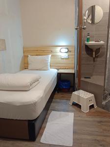 um pequeno quarto com 2 camas e um lavatório em Myera Hotel em Banting