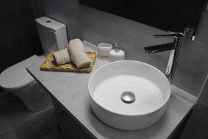 a bathroom with a white sink and a toilet at City Center Apartment 1 in Alexandroupoli