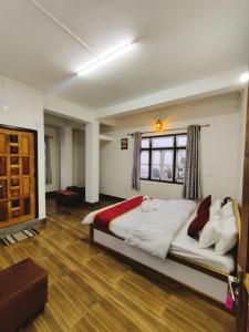 1 dormitorio con 1 cama grande y suelo de madera en Jain Homestay, en Darjeeling