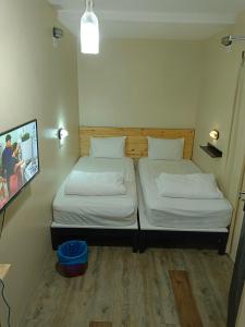 two beds in a small room with a picture on the wall at Myera Hotel in Banting