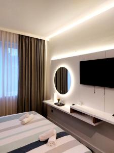 a hotel room with two beds and a flat screen tv at Swiss Plus Hotel in Bihać