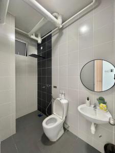 La salle de bains est pourvue de toilettes, d'un lavabo et d'un miroir. dans l'établissement KiRA Drawbridge Homestay with pool WIFI NETFLIX near KTCC Mall, à Kuala Terengganu