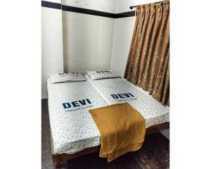 a bed with two pillows on it in a room at Devi Deluxe Lodge By WB Inn in Secunderabad