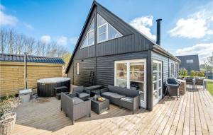 een zwart huis met een terras met een hot tub bij Nice Home In Fars With Kitchen in Farsø