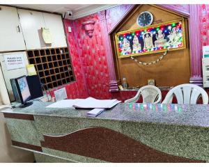 un mostrador en un restaurante con mesa y sillas en Devi Deluxe Lodge By WB Inn, en Secunderābād