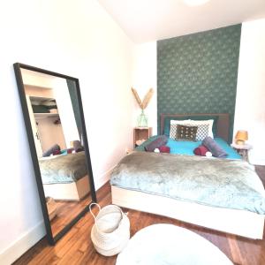 a bedroom with a bed and a mirror at Joli Appartement 20 minutes Paris, Orly, CDG, Disney, Wi-Fi & Netflix in Le Perreux-Sur-Marne