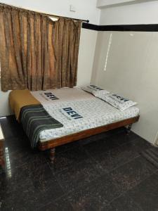 Cama pequeña en habitación con ventana en Devi Deluxe Lodge By WB Inn, en Secunderābād