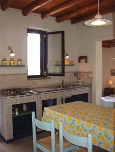 a kitchen with a table and a counter with a sink at Residence il Baglio in Porto San Giorgio