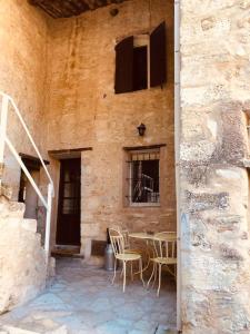 een patio met stoelen en een tafel in een gebouw bij Maison de caractère au coeur de la Provence in Robion en Luberon