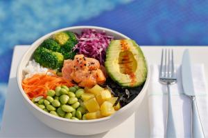 a bowl of food with vegetables and rice and a fork at Marriott Resort Palm Jumeirah, Dubai in Dubai