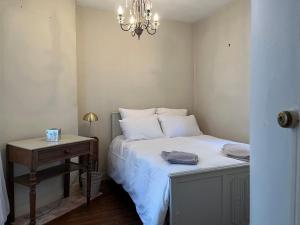 Un dormitorio con una cama y una mesa con una lámpara de araña. en Maison de pêcheur Trouville - Le Colibri, en Trouville-sur-Mer
