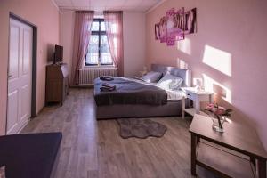 1 dormitorio con paredes rosas, 1 cama y 1 mesa en Ubytování v soukromí v Oáze klidu v Jindřichově Hradci, en Jindřichův Hradec