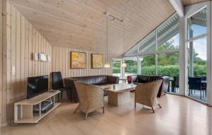 ein Wohnzimmer mit einem Tisch, Stühlen und einem TV in der Unterkunft Amazing Home In Rdby With 4 Bedrooms, Sauna And Wifi in Kramnitse