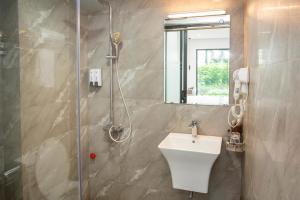 a bathroom with a shower with a sink and a shower at Lake View Hotel in Hanoi