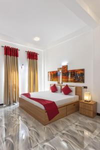 um quarto com uma cama grande e almofadas vermelhas em White Land City Hotel em Dambulla