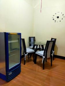 Habitación con mesa, sillas y reloj en la pared en Vacation Station Baguio, en Baguio