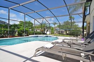 a swimming pool with a bunch of lounge chairs at Ainsdale Haven home in Kissimmee