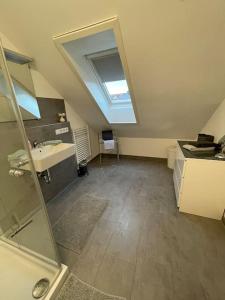 un bagno mansardato con lavandino e specchio di Melli‘s Seenahe Ferienwohnung a Langenargen