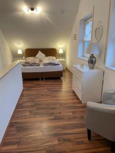 una camera con letto e pavimento in legno di Melli‘s Seenahe Ferienwohnung a Langenargen