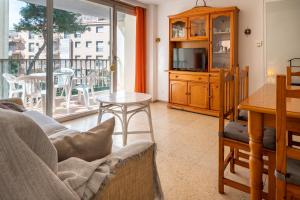 een woonkamer met een bank, een tv en een balkon bij AT129 Apartamento en primera línea de la playa in Torredembarra