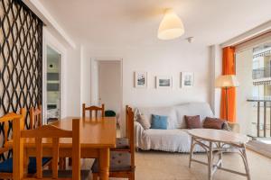 een woonkamer met een bank en een tafel bij AT129 Apartamento en primera línea de la playa in Torredembarra +11 foto's