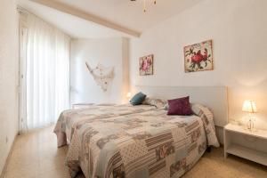 een slaapkamer met een groot bed en een raam bij AT129 Apartamento en primera línea de la playa in Torredembarra