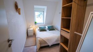 um pequeno quarto com uma cama e uma janela em # Le 4 # Très beau appartement T3 Neuf, tout confort, Mulhouse centre ville em Mulhouse