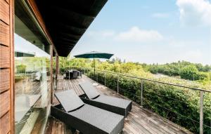 a balcony with two chairs and an umbrella at Lovely Home In Allinge With House Sea View in Allinge
