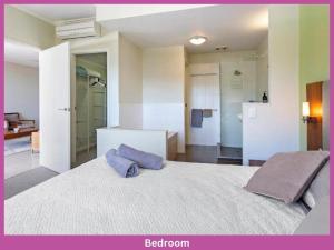 a bedroom with a large bed with two pillows on it at 52 Airlie Beach Beauty at The Summit in Airlie Beach
