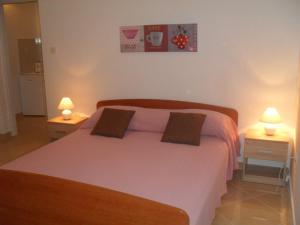 una camera da letto con un grande letto con due comodini di Studio Apartmani Krstina a Sukošan (San Cassiano)