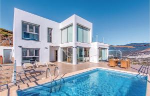 a villa with a swimming pool in front of a house at Stunning Home In Cmpeta With 4 Bedrooms, Wifi And Outdoor Swimming Pool in Árchez