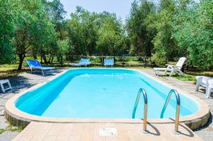 einen Pool mit 2 Stühlen und einem Tisch in der Unterkunft Agriturismo La Fragolaia in Marina di Grosseto