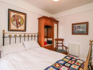 een slaapkamer met een bed en een stoel bij Hill Brow in Acton Scott