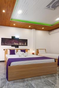1 dormitorio con 1 cama grande con sábanas moradas en White Land City Hotel en Dambulla