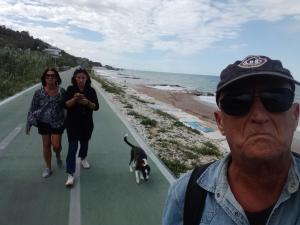 un homme et deux femmes promènent un chien sur la plage dans l'établissement Casale Costa dei Trabocchi, à San Vito Chietino