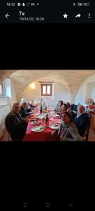 Un groupe de personnes assises à une longue table dans l'établissement Casale Costa dei Trabocchi, à San Vito Chietino