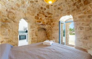 - une chambre avec un lit dans un mur en pierre dans l'établissement Awesome Home In Ostuni -br- With Kitchen, à Ostuni