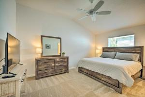 1 dormitorio con cama, espejo y TV en Sunny Florida Escape with Pool Access, Patio and Grill en Wildwood