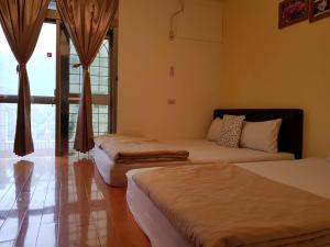 a bedroom with two beds and a couch and a window at Youran B&B in Jiufen