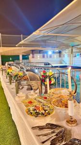 a buffet line with plates of food on a table at Qasayed Hotel فندق قصائد in Salalah