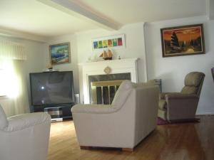 uma sala de estar com duas cadeiras e uma televisão em Master Bedroom with Garden View em Huntington